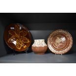 Three pieces of slipware studio pottery, to include slipware plate, and a two tone vase with incised