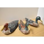 A group of three early 20th Century painted wood duck decoys, measuring 27cm long