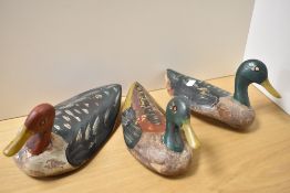 A group of three early 20th Century painted wood duck decoys, measuring 27cm long