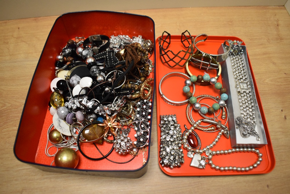 An assorted collection of costume jewellery, to include bangles, bead necklaces, and brooches