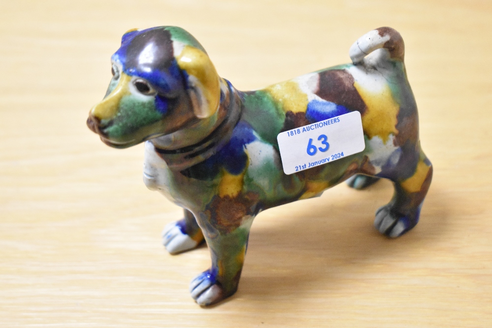 An early 20th Century spongeware glazed dog study, multi-coloured, having repairs to tail and