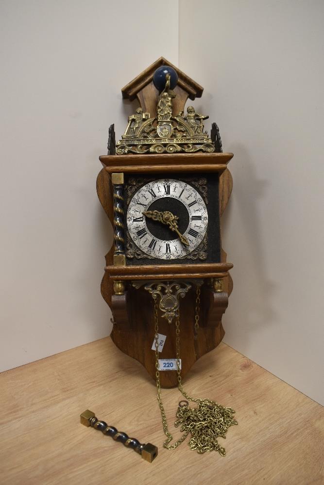 A vintage wall clock, having oak case, brass decorations and Roman numerals to face.