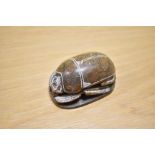 An Egyptian carved soapstone scarab beetle paperweight, measuring 10cm long