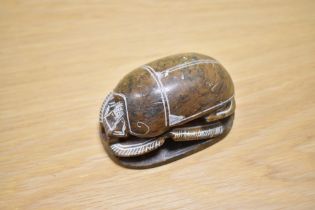 An Egyptian carved soapstone scarab beetle paperweight, measuring 10cm long