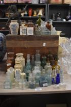 A collection of vintage and antique glass bottles, paste pots, ink wells and similar, including blue