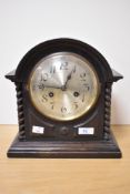 An early 20th Century oak cased mantel clock, with domed top, above a silvered Arabic dial,