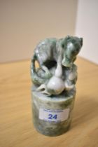 A Chinese variegated green stone seal, carved as a horse and with cylindrical base, measuring 12cm