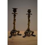 A pair of late 19th Century gilt metal candlesticks, modelled with lizards and grapes, and raised on