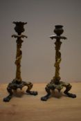 A pair of late 19th Century gilt metal candlesticks, modelled with lizards and grapes, and raised on