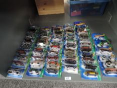 A shelf of Mattel Hot Wheels die-casts, 2006 period, 55 in total, all on bubble display cards, all