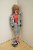 A 1959 Mattel Midge Barbie Doll having adjustable body wearing two piece grey suit with Barbie