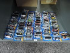 A shelf of Mattel Hot Wheels die-casts, 2005 period, 61 in total, all on bubble display cards, all