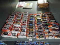 A shelf of Matchbox die-casts, 2000 period onwards, 80 in total, all on bubble display cards, all