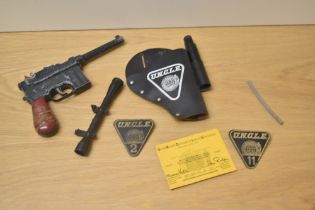 A collecection of UNCLE Toys including Lone Star Pistol and Holster, Sights, Card and two leather