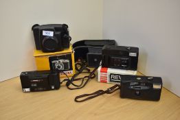 Four cameras. A Minolto AF-E , a Revue 400 (boxed), a Goldline Clipper 3, and a Kodak Brownie 44A