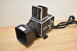 A Hasselblad 500C/M medium format camera with Carl Zeiss Panar 2,8/80 lens, lens hood, having