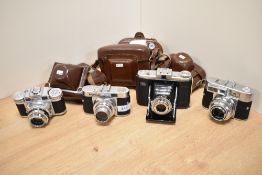 Four cameras. A Zeiss Ikon Nettar, a Voigtlander Vito B, a Voigtlander Vitomatic II, and a Braun