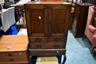 An Edwardian mahogany cabinet on cabriole legs , with fitted interior and inlaid decoration,