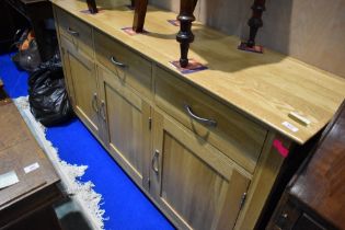 A modern light beech effect sideboard having triple drawer and cupboards, width approx. 160cm
