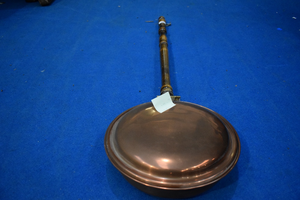 A traditional copper warming pan and reproduction corner whatnot