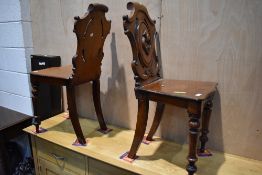 A pair of 19th Century mahogany hall chairs of typical shield back design