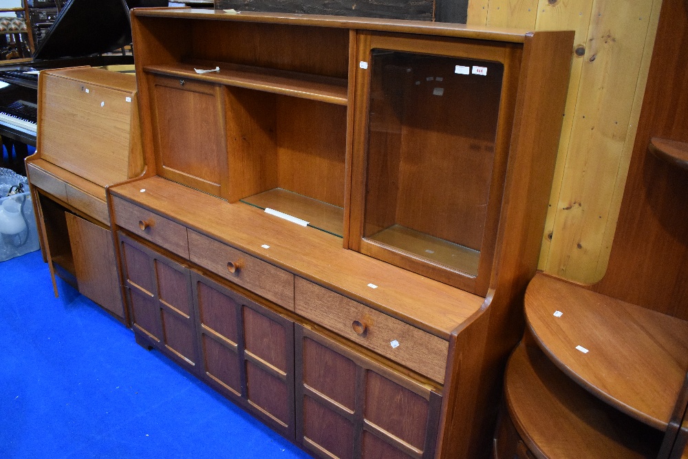 A vintage teak sideboard/dresser by Nathan, having cocktail and display section over triple frieze