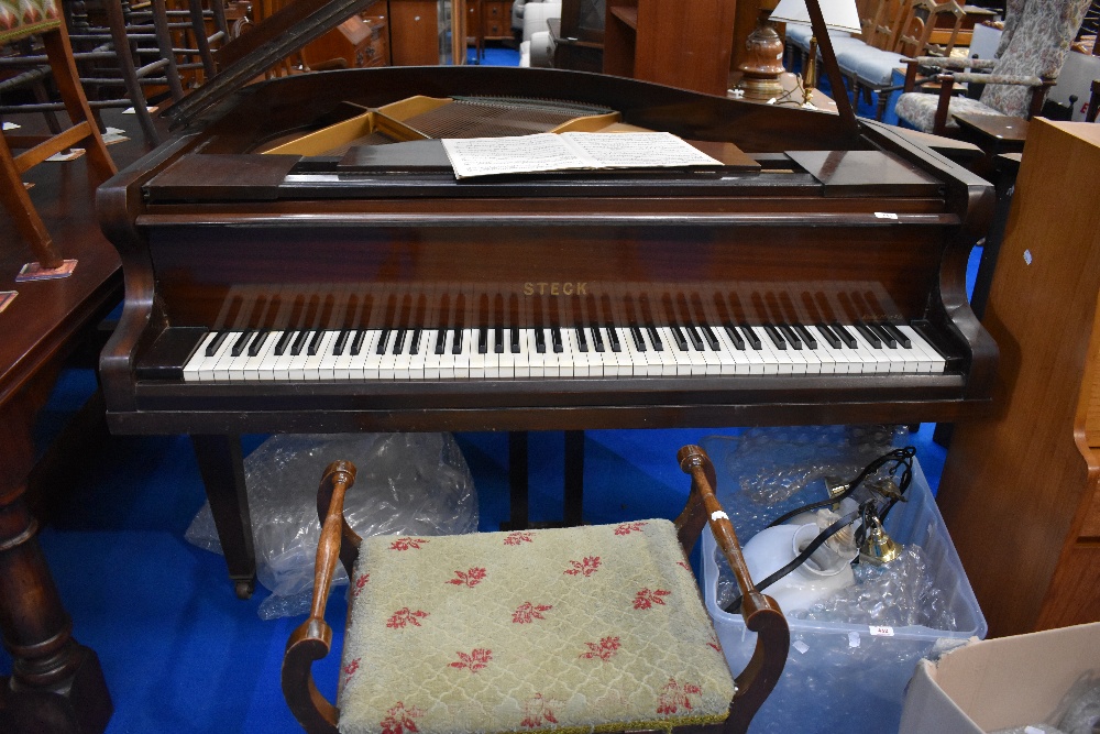 An early 20th Century mahogany cased baby grand piano by Steck having metal overstrung frame,