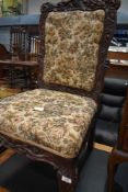 A 19th Century nursing chair having carved oak foliate and mythical frame with later upholstery,