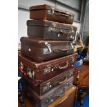 A selection of vintage luggage cases, including leather , some with travel labels