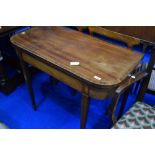 An Edwardian mahogany fold over card table , having line inlay decoration on square tapered legs