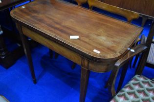 An Edwardian mahogany fold over card table , having line inlay decoration on square tapered legs