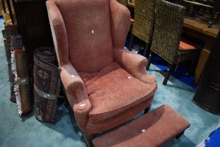A traditional wingback armchair and footstool