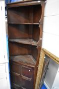 A vintage dark stained Ercol style corner shelf with cupboard under