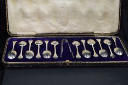A cased set of twelve late Victorian silver coffee spoons and sugar tongs, with trefoil terminals