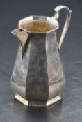 An Edwardian silver milk jug, of octagonal baluster form with scrolled handle and short swept spout,