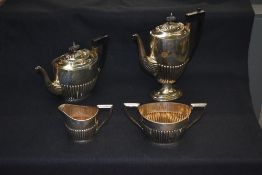 An Edwardian silver four-piece tea set, comprising teapot, hotwater pot, sugar and cream the