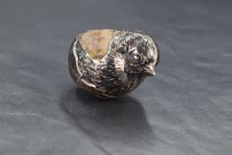 An Edwardian silver 'hatching chick' form pin cushion, marks for Chester, rubbed date letter,