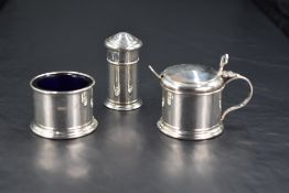 A George V silver three-piece condiment set, comprising salt, pepperette and mustard with spoon,