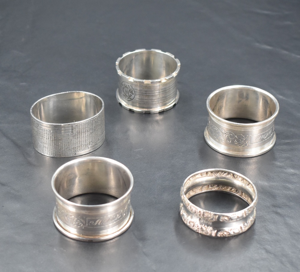 A group of five silver napkin rings, to include castellated ring, Birmingham 1922, maker rubbed