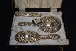 A Queen Elizabeth II silver mounted four-piece dressing table set, comprising hand mirror, hair