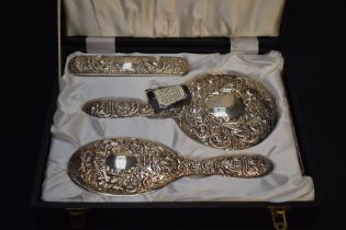 A Queen Elizabeth II silver mounted four-piece dressing table set, comprising hand mirror, hair