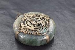 A Chinese white metal-mounted mottled green hard stone pendant, of circular form with white metal