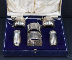 A part George VI silver condiment set, comprising lidded salt, mustard (with spoons) and two