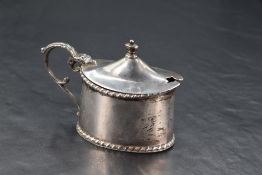 A George V silver mustard, of oval form with hinged cover, scrolled handles and rope-twist edge