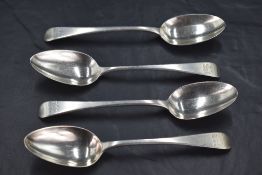 A group of four George III silver Old English pattern dessert spoons, each with Hanoverian reverse