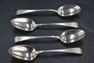 A group of four George III silver Old English pattern dessert spoons, each with Hanoverian reverse