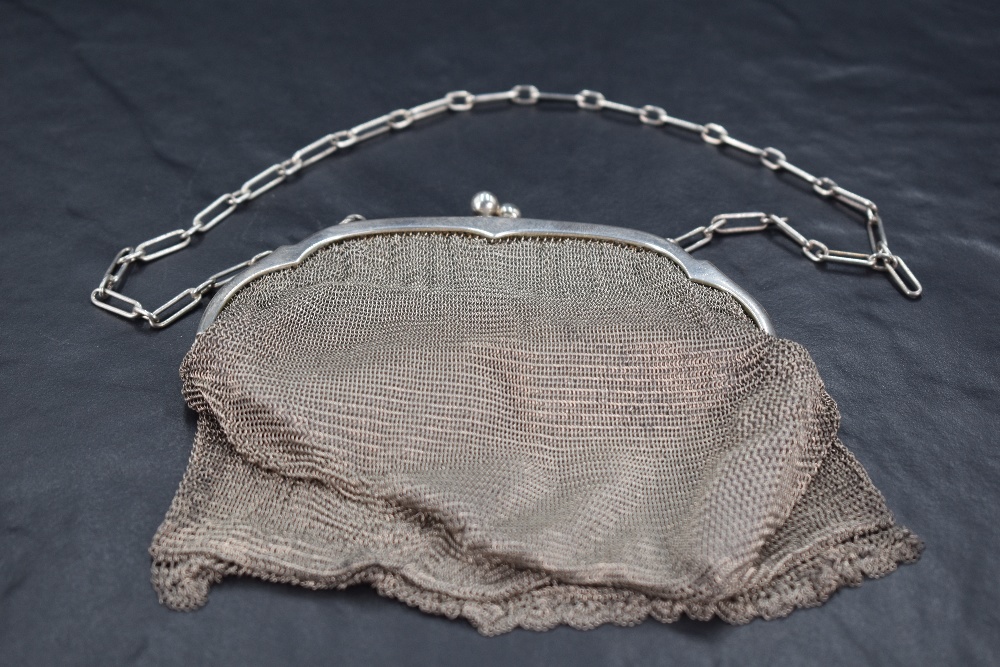 A .925 grade white metal mesh purse, of arched and shaped form with raised ball clasp and oblong