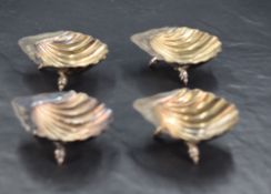 A set of four Victorian silver scallop shell form salts, each with three shell-form feet, marks