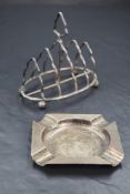 A late Victorian silver four-division toast rack, of shaped arch form with central carrying
