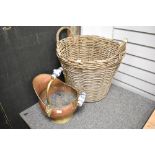 A wicker log basket and a copper fire helmet with ceramic handles.
